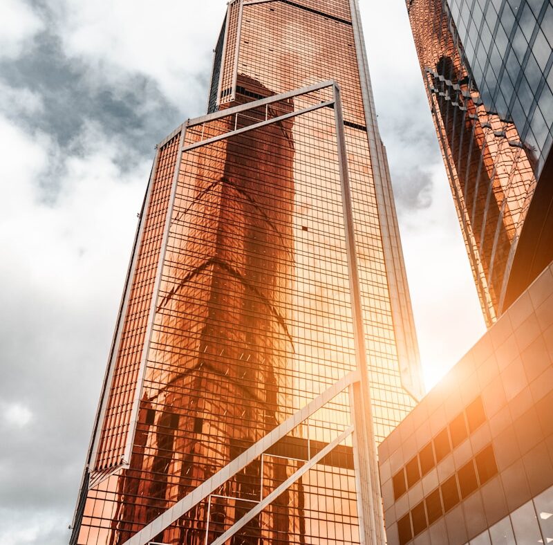 gold high-rise building under cloudy sky